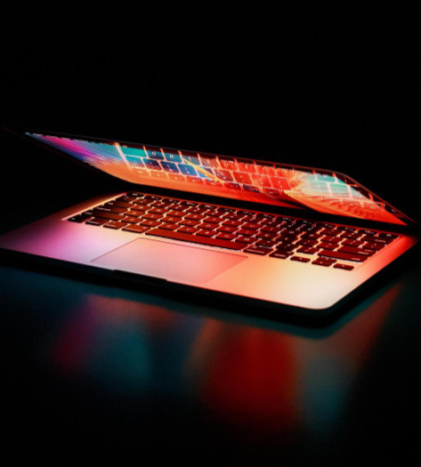 web design photo of a laptop half closed with orange lighting